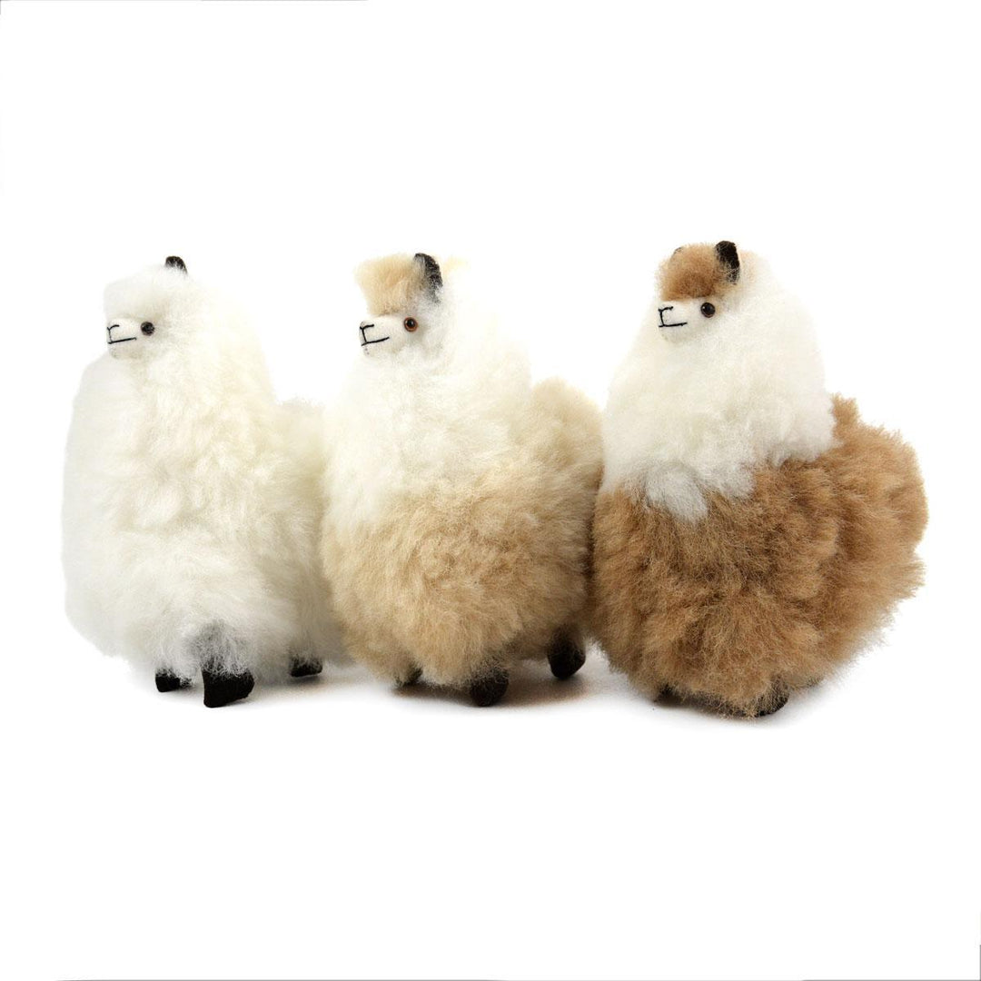 Three plush alpaca llamas in white and beige colors, standing upright.