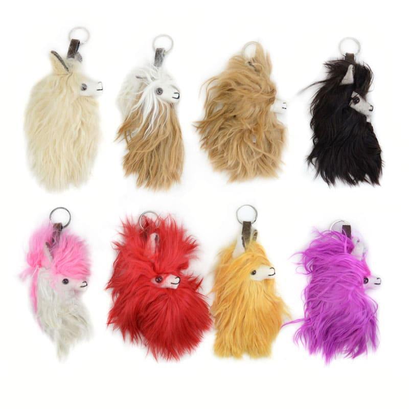 A collection of alpaca llama head keychains in various colors including beige, black, red, yellow, and purple.