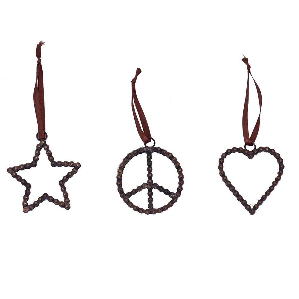 Three Christmas tree ornaments in the shapes of a peace sign, a heart, and a star on a white background.