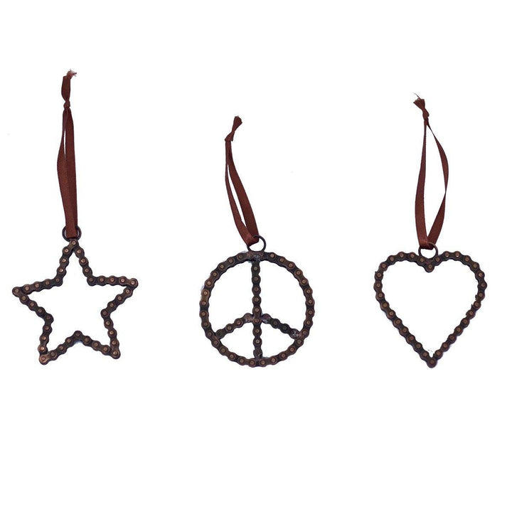 Three Christmas tree ornaments in the shapes of a peace sign, a heart, and a star on a white background.