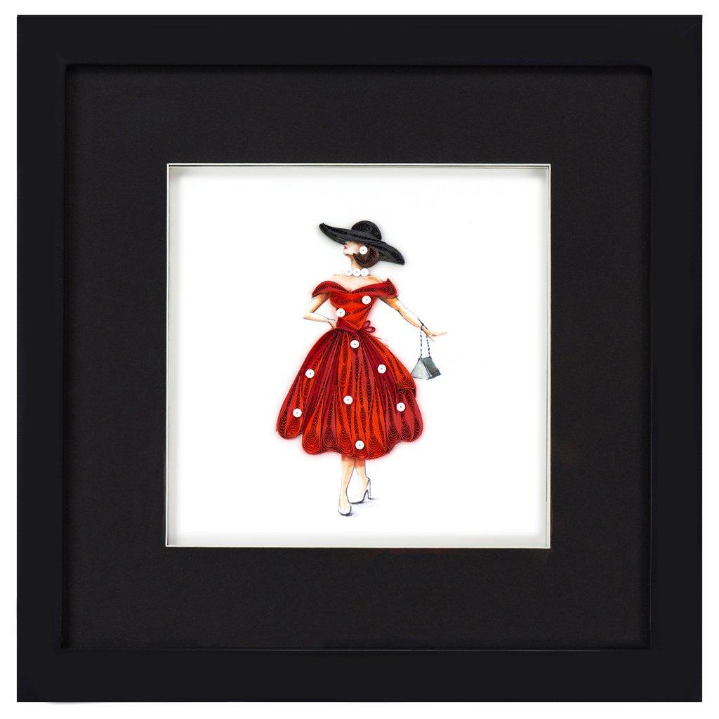 A shadow box frame made of wood and glass, displaying a quilled card picture of a woman in a red dress.