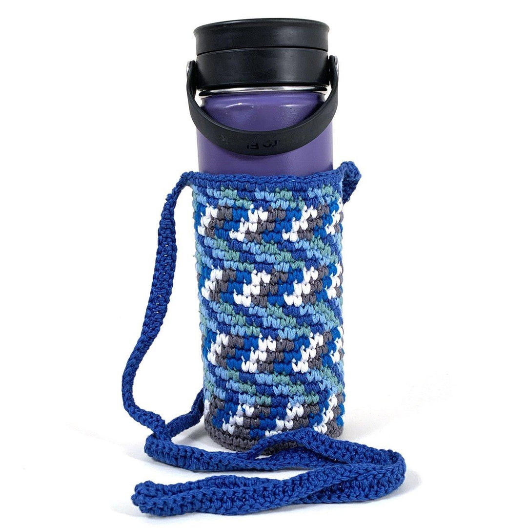 Hand knitted blue water bottle holder with white and gray chevron design with blue shoulder strap.