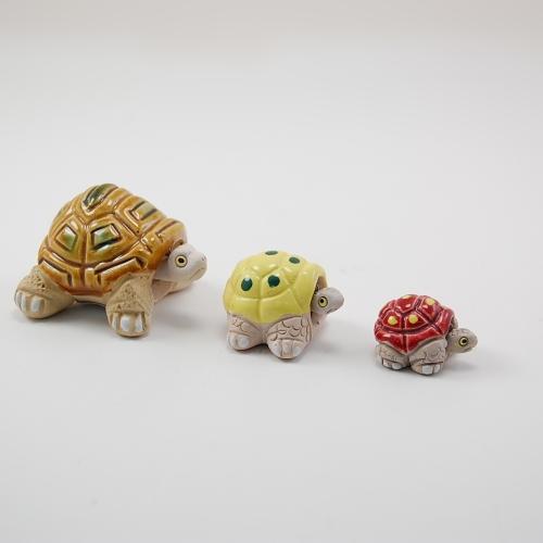 A set of three ceramic turtle figurines in different colors.