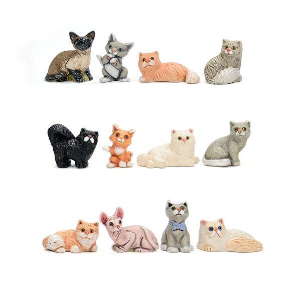 A set of ceramic pet figurines, including cats in various colors and poses.