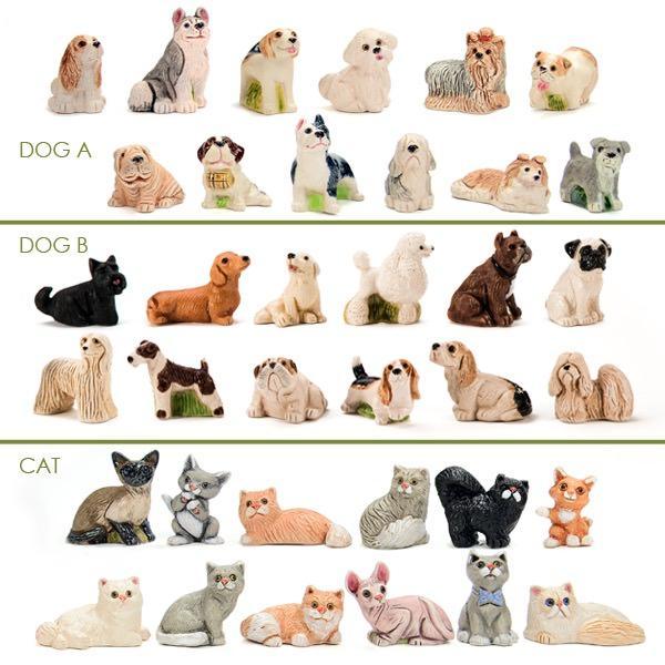 A set of ceramic pet figurines, including both dogs and cats in various colors and poses.