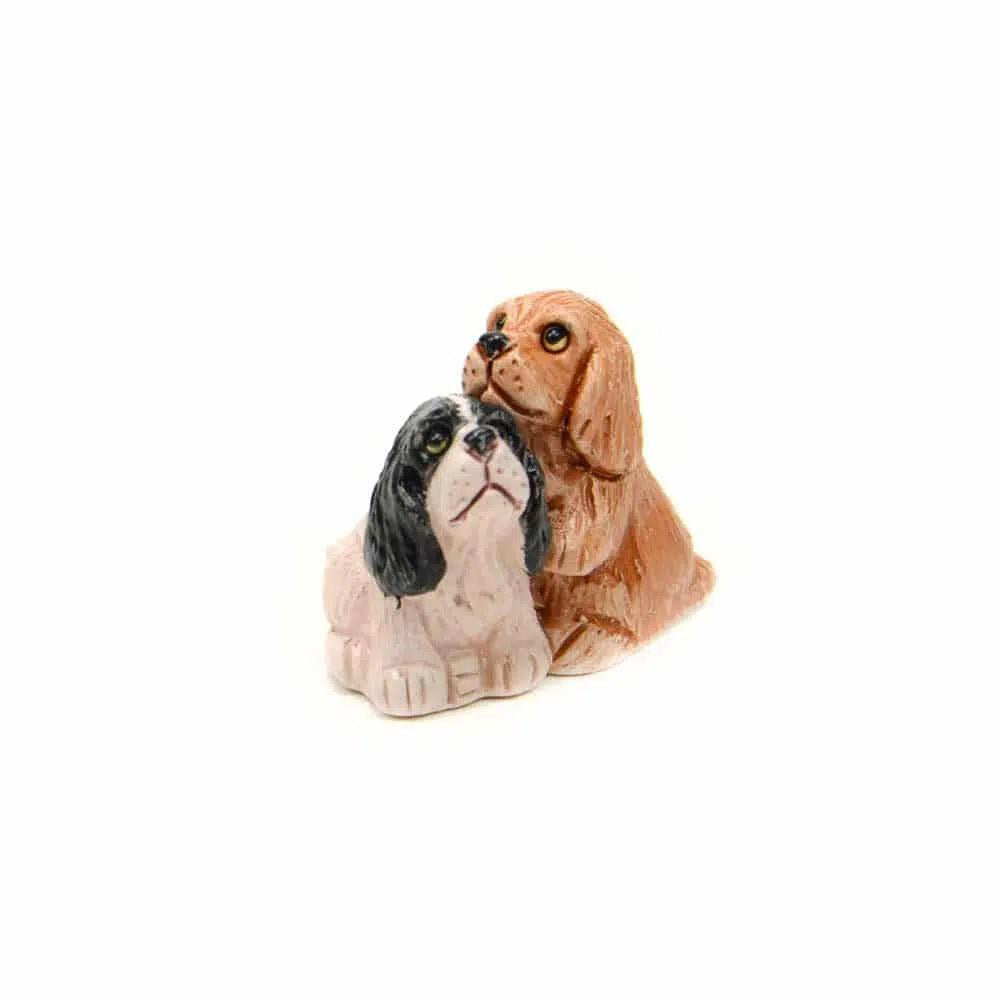 Two ceramic dog figurines on a white background.