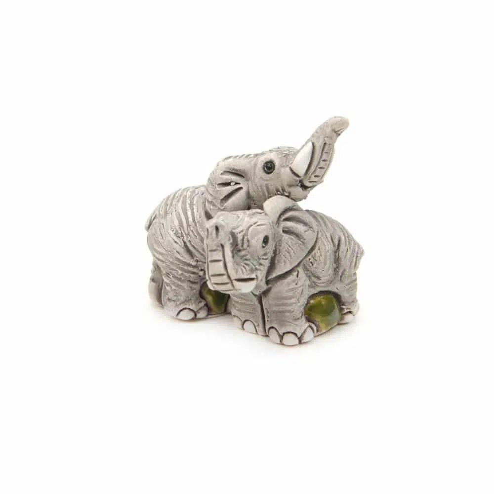 Two ceramic elephant figurines on a white background. 