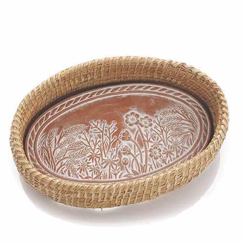 A terracotta breadwarmer with incised designs, featuring a basket weave pattern around the edge.