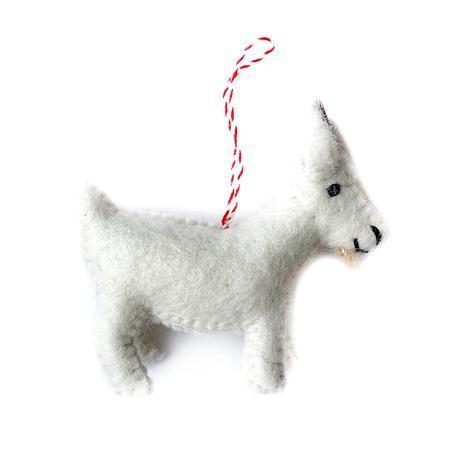 A handmade felt goat ornament with a red and white striped ribbon for hanging on a Christmas tree.