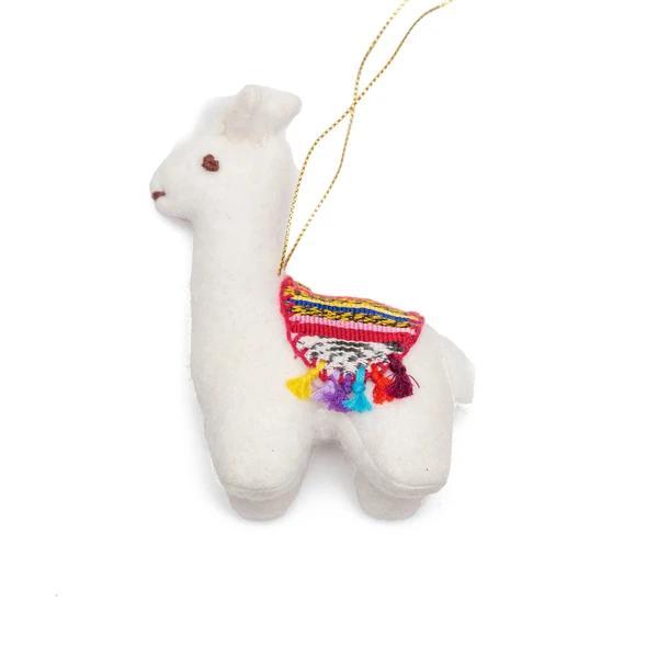 A felt llama ornament with fringes on the side, primarily in beige color with colorful fringes, hanging from a string.