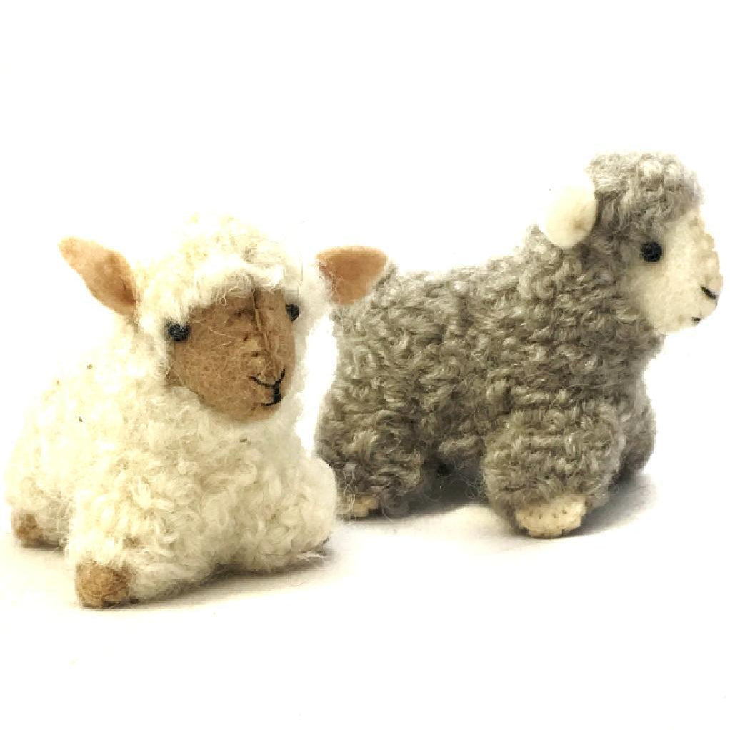 Two handmade felt sheep ornaments, one lying down and the other standing, crafted from felted wool in beige and white colors.