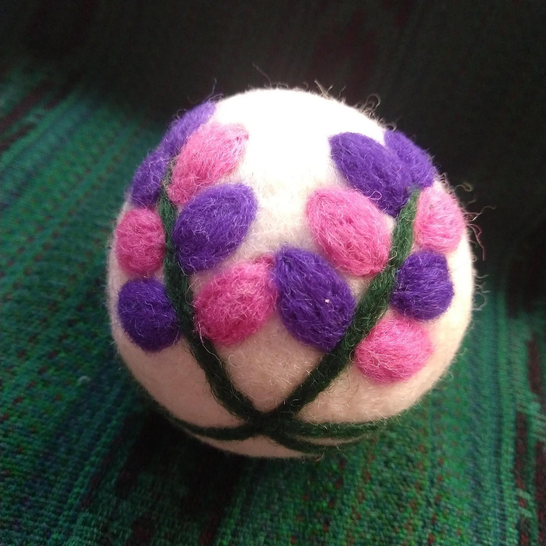 flower dryer ball on a green knit backgound