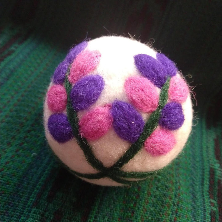 flower dryer ball on a green knit backgound