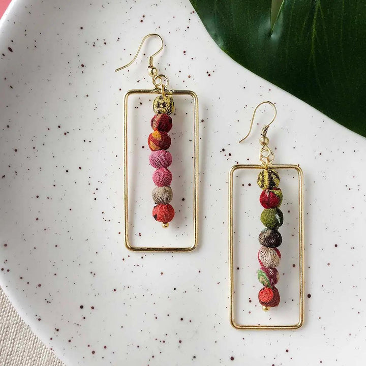 Framed gold kantha earrings with multicolored beads.