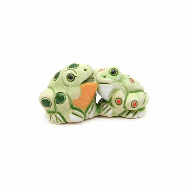 Two ceramic frog figurines on a white background.