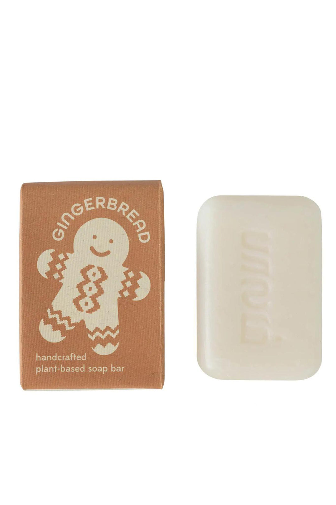 A bar of gingerbread-scented soap next to its packaging, which features a gingerbread man and the text 'Handmade plant-based soap bar'.