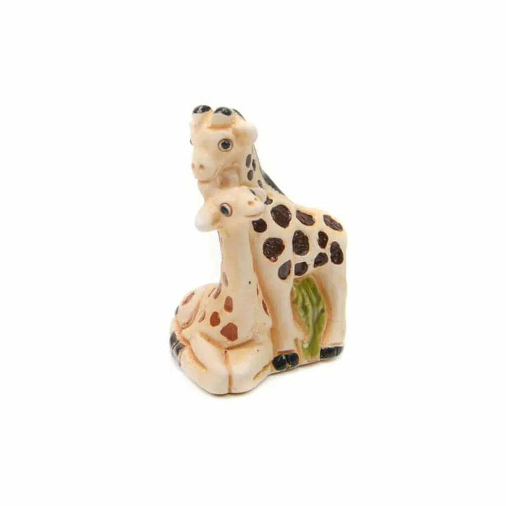 Two ceramic giraffes hugging on a white background. 
