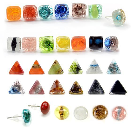 A collection of various glass stud earrings in different colors and patterns, displayed in rows. They come in various shapes including square, round, and triangular, and are attached to metal posts.