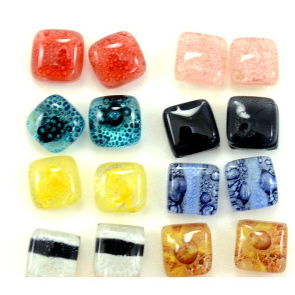A collection of various glass stud earrings in different colors and patterns, displayed in rows. 