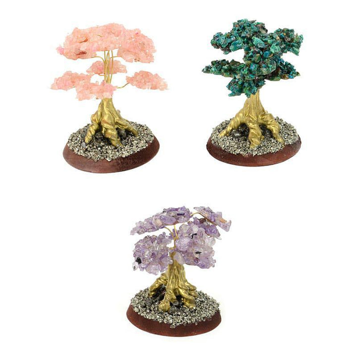 A set of four decorative stone trees with wire branches, featuring different colors such as pink, green, purple, and yellow, placed on circular wooden bases.