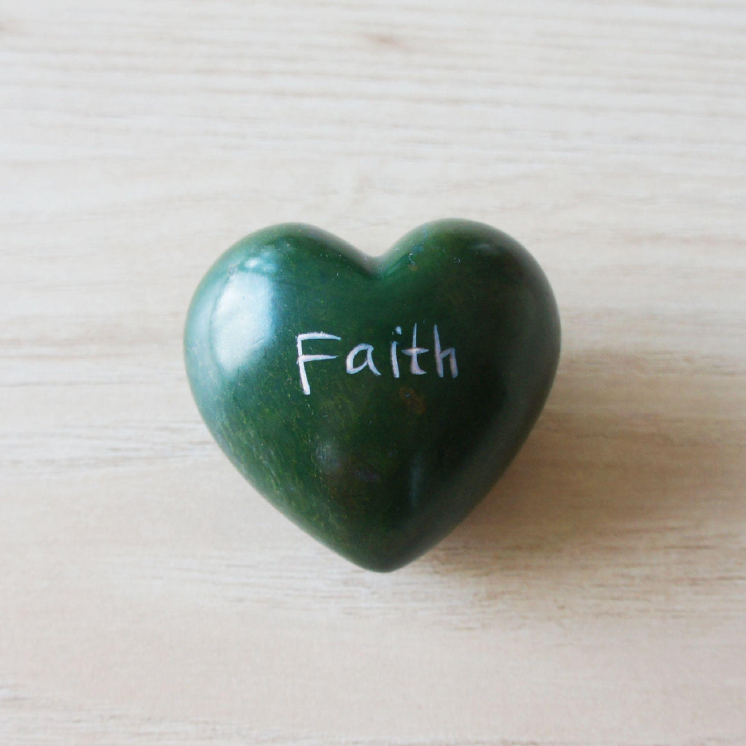 A green kisii faith heart on a wooden background 