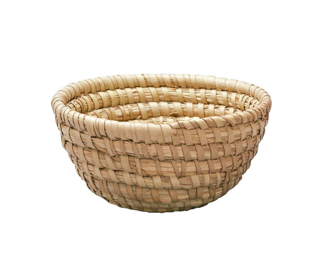 A handwoven beige grass basket with a round shape and a 6 inch diameter.