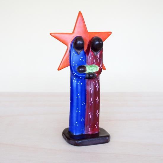 Colorful Kisi stone nativity scene with a red star behind Joseph and Mary.