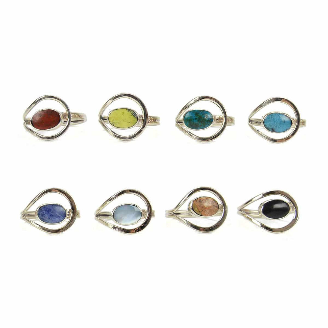A collection of four rings with unique loop designs, featuring semi-precious stones in various colors, crafted from alpaca silver.