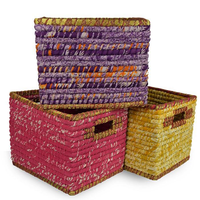 Stack of three large fabric wrapped baskets in vibrant colors, with inset handles, made from Kaisa grass and recycled cotton sari.