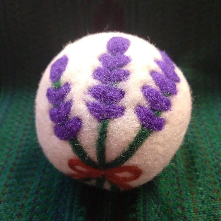 lavender dryer ball on a green knit background