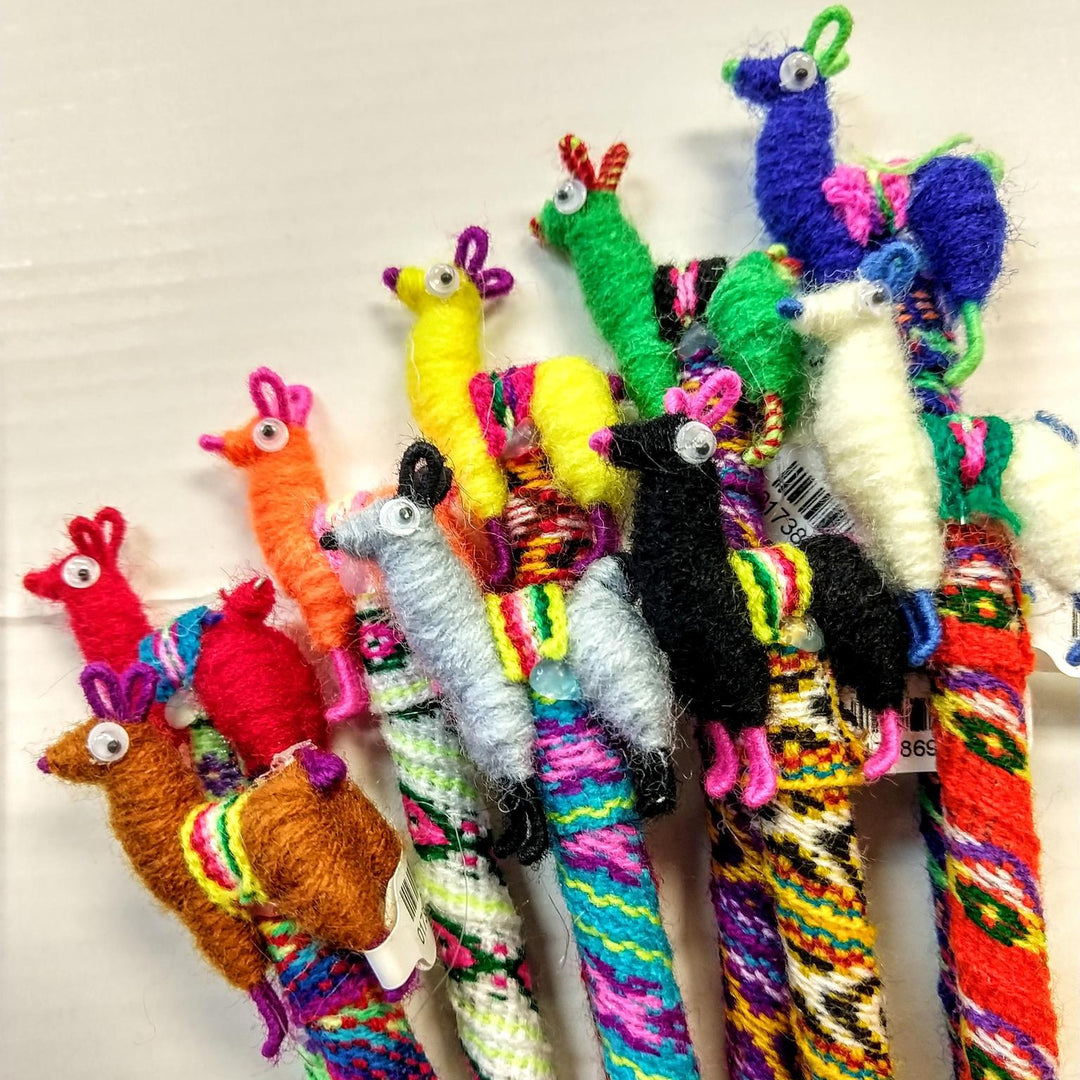 A collection of colorful handcrafted llama-shaped pens with colorful thread and alpaca wool.