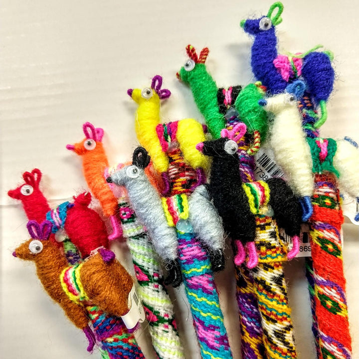A collection of colorful handcrafted llama-shaped pens with colorful thread and alpaca wool.