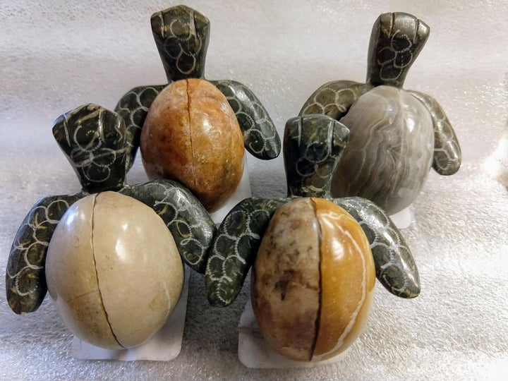 A pair of decorative turtle-shaped bowls made of marble and onyx, with one turtle in a speckled egg pattern and the other in a solid black and gray color.