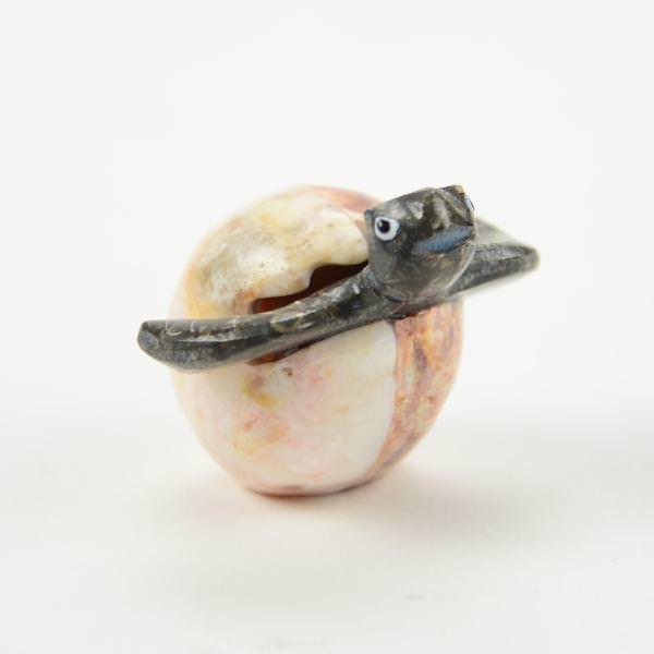 One decorative turtle made of marble and onyx, peeking out of the egg. 