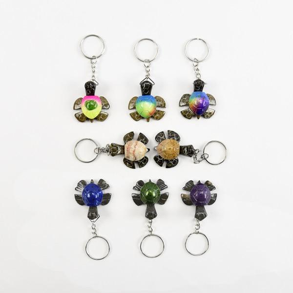A collection of marble and onyx turtle-shaped keychains in various colors.