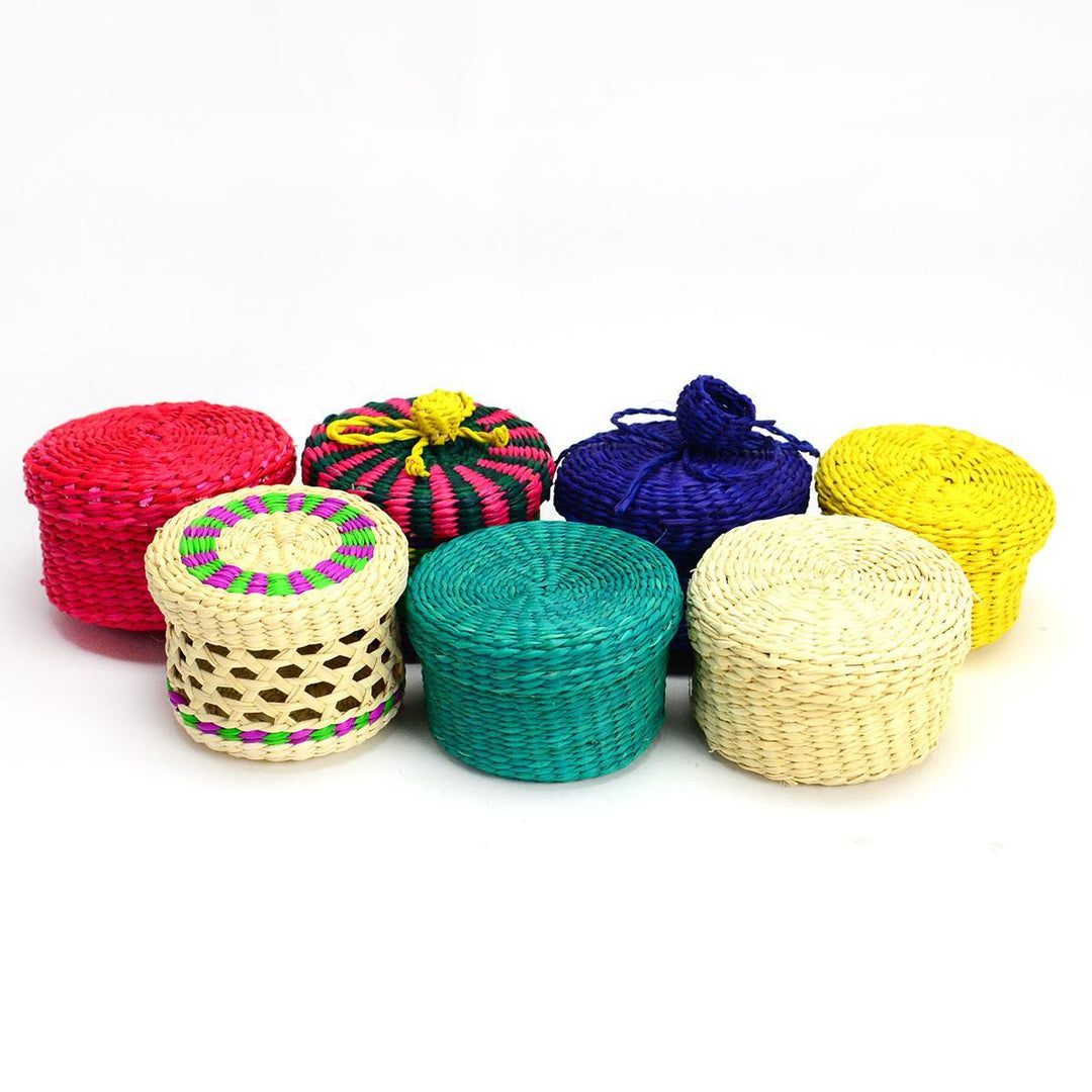 A collection of mini lidded baskets made of woven grass, featuring various colors and patterns.