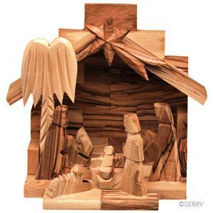 A nativity creche scene carved from olive wood, showing the stable, angel, and figures of Mary, Joseph, and baby Jesus.
