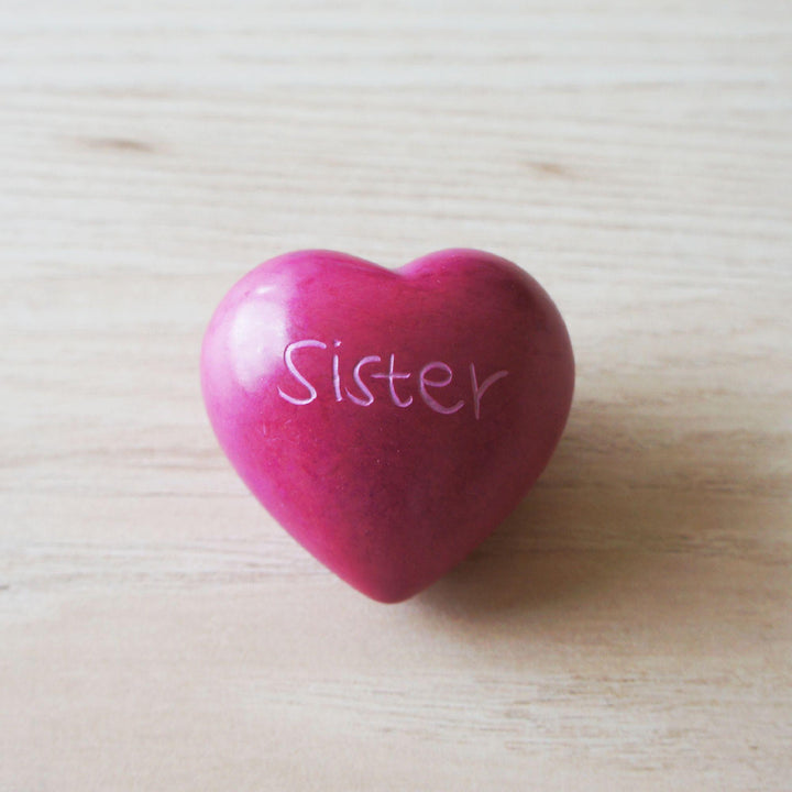 A pink kisii sister heart on a wooden background 