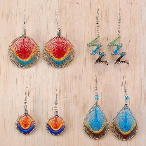A collection of colorful racquet thread earrings displayed on a wooden surface. The earrings come in various shades and designs, featuring a common thread wrapping technique.