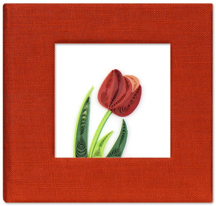 A handcrafted red sticky note cover with a floral design, featuring a quilled motif in a frame.