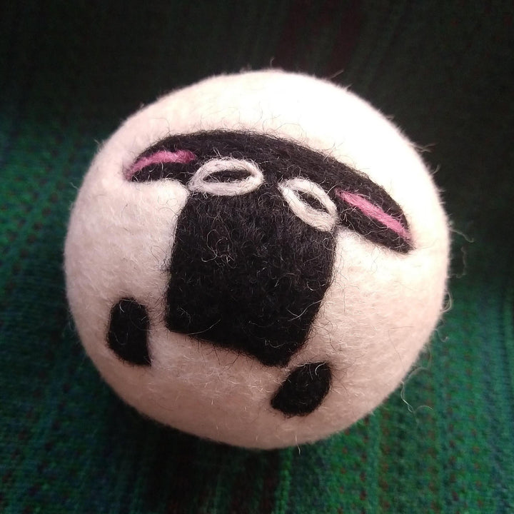 sheep dryer ball on a green knit background