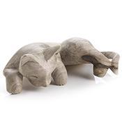 A wooden cat figurine with paws and tail draped over a shelf.