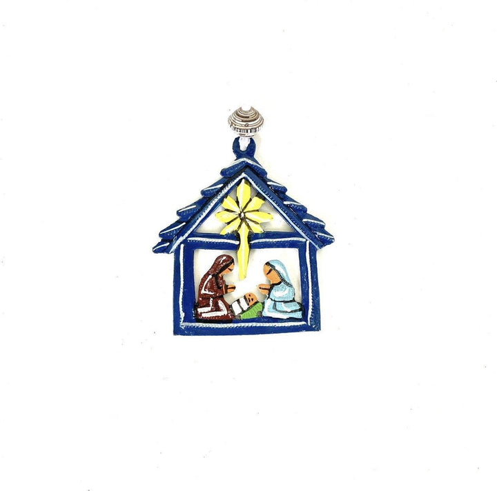 A blue metal nativity ornament on a white background. 
