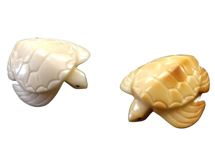 A hand-carved white tagua nut figurine of sea turtles, with a smooth finish and displayed against a white background.
