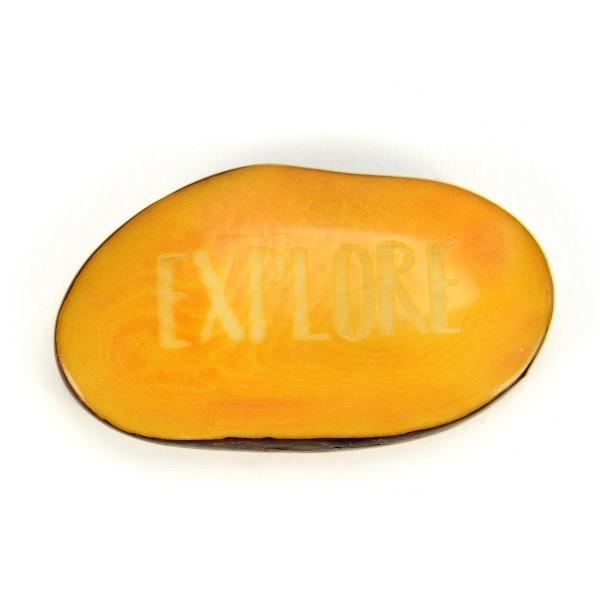 a yellow tagua nut with the word 'explore'