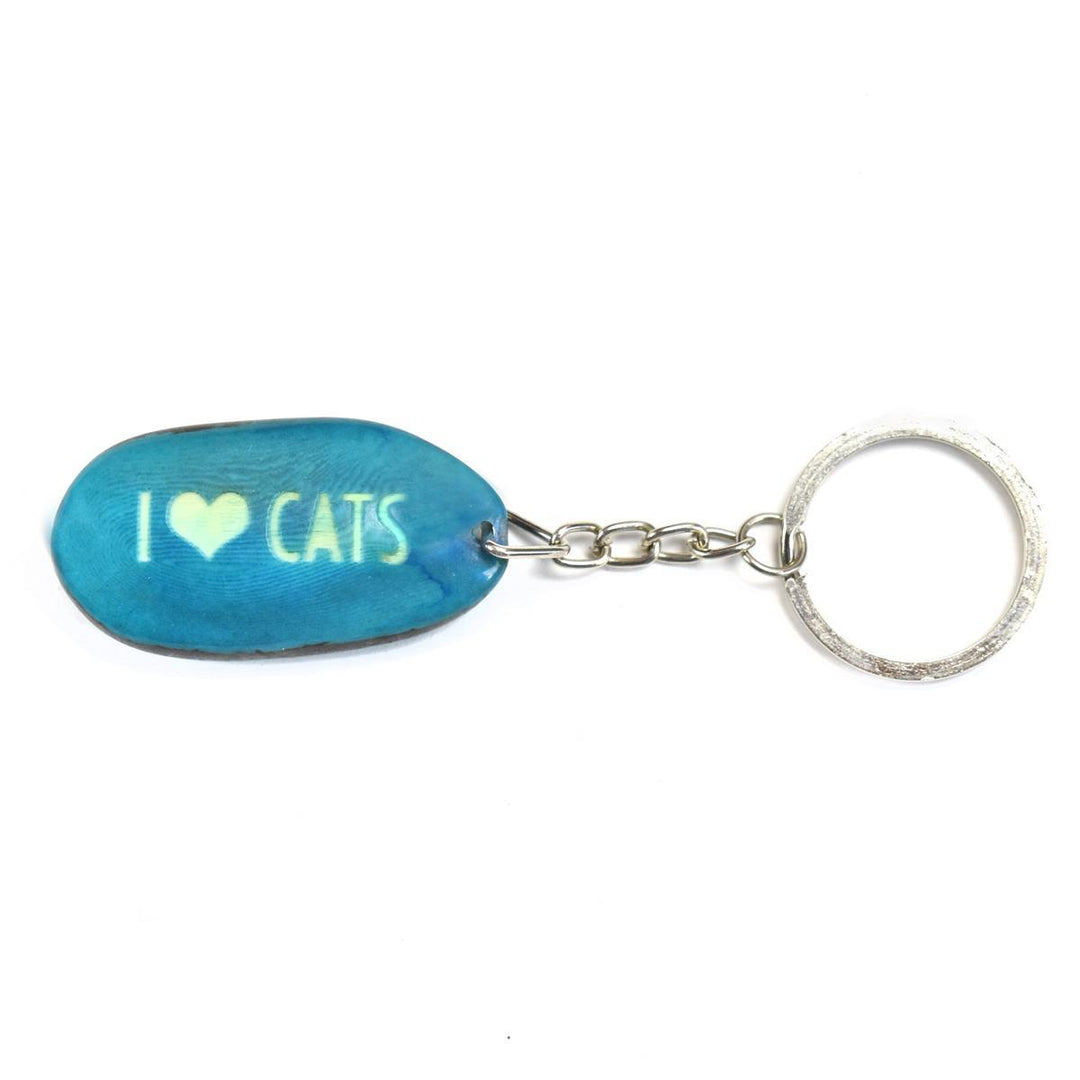 A aqua tagua nut keychain with the word 'I heart cats' engraved on it, attached to a metal keyring.