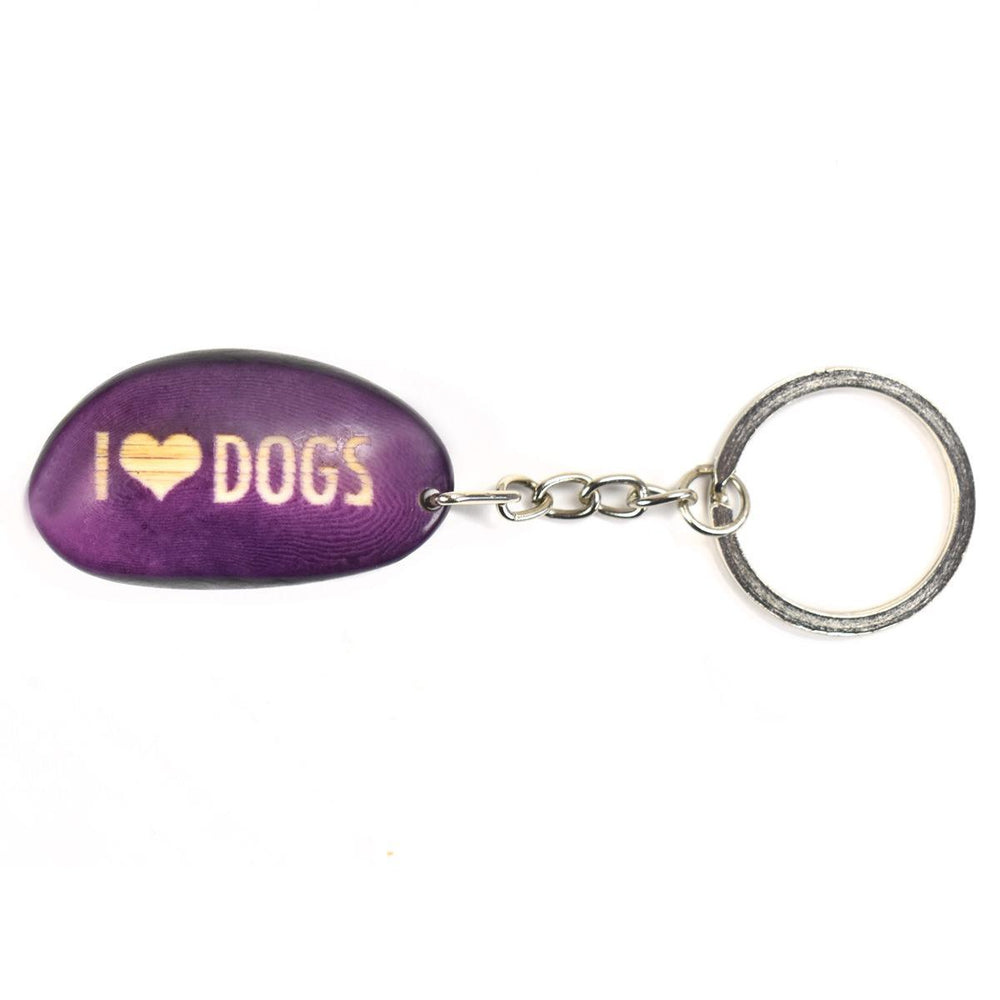 A purple tagua nut keychain with the word 'I heart dogs' engraved on it, attached to a metal keyring.