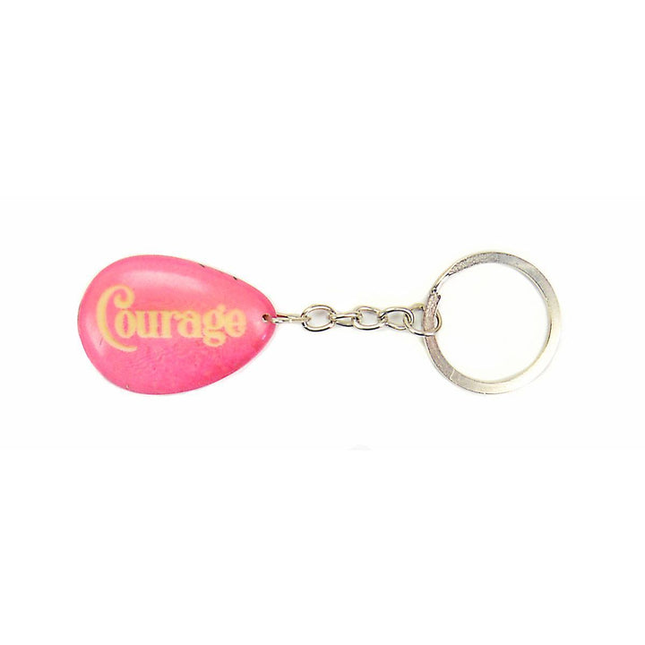 a pink tagua keychain with the word 'courage' engraved. 