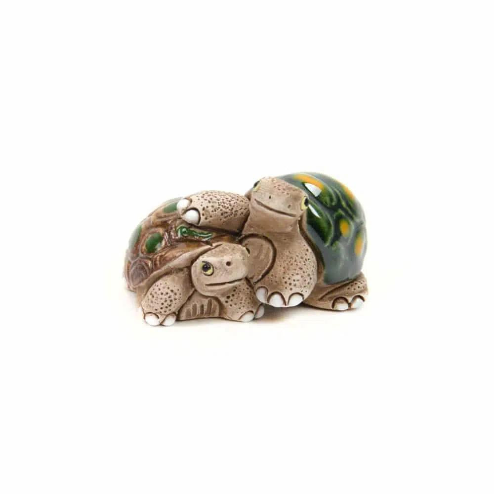 Turtle ceramic animal duo hugging on a white background.