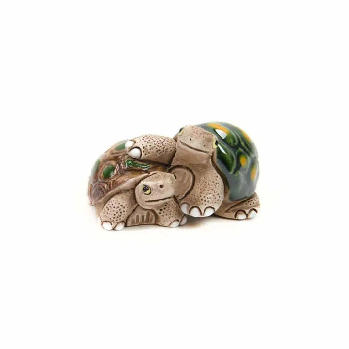 Turtle ceramic animal duo hugging on a white background.